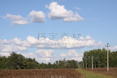 斜角的干草地和布满云彩的天空