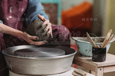 雕刻家妇女在陶工轮上做一个罐子。