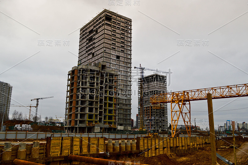 一个大型的现代化建筑工地，在建筑和房屋用电器和许多高大的塔和固定式工业强大的起重机和建筑材料