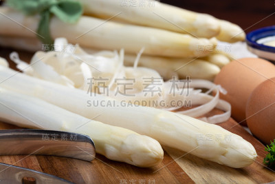 一串新鲜生白芦笋和削皮刀，如何削芦笋蔬菜