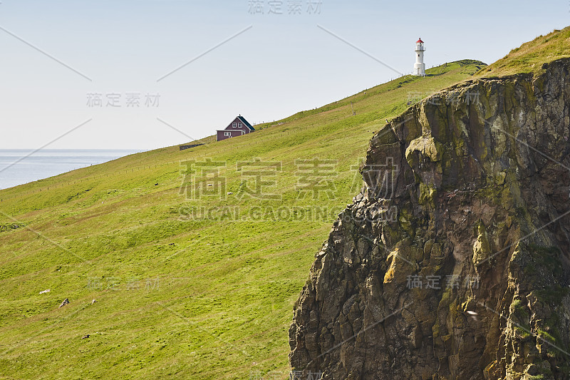 法罗群岛上的迈肯斯灯塔和悬崖。徒步旅行具有里程碑意义的