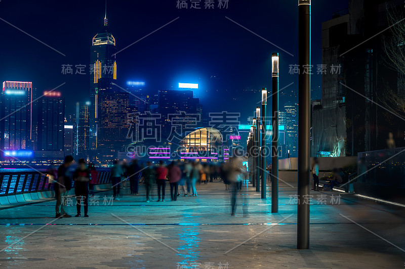 香港城市夜景。在海滨散步的游客