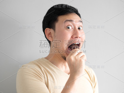 滑稽脸男吃巧克力香草冰棍。