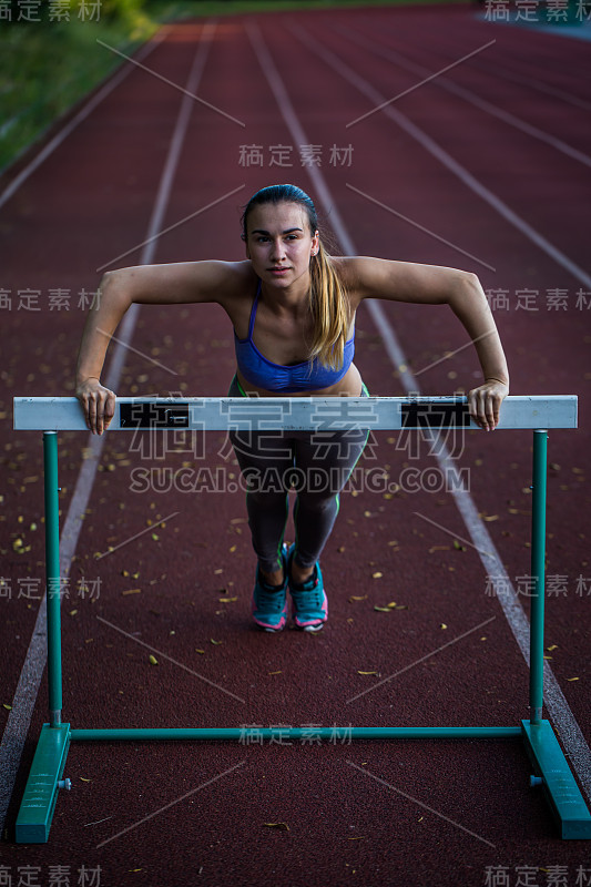 漂亮的运动女孩在体育场热身，