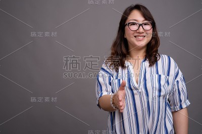 工作室拍摄的成熟美丽的亚洲女商人在灰色的背景