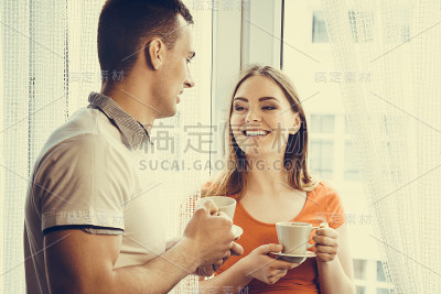 年轻夫妇在家里喝茶或喝咖啡