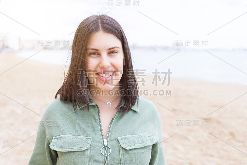 年轻漂亮的女人在海滩上笑得很开心