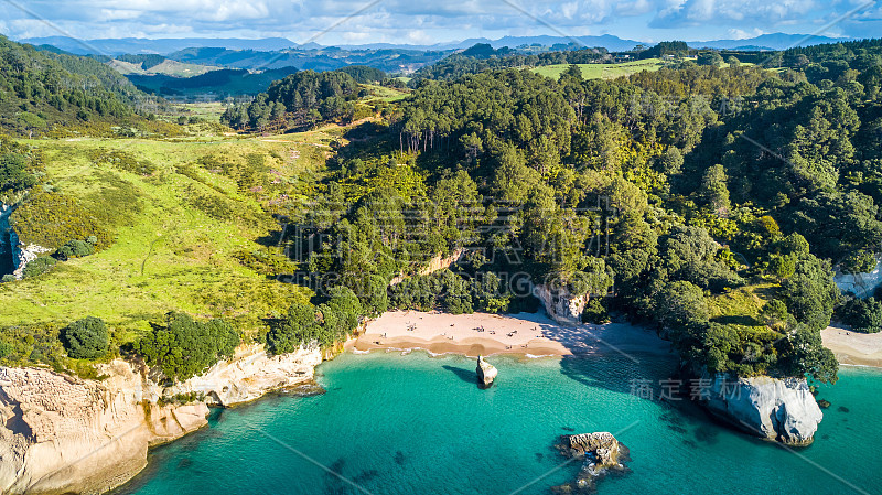 鸟瞰图上的一个偏远的海岸与小海湾和山脉的背景。乌木,新西兰。