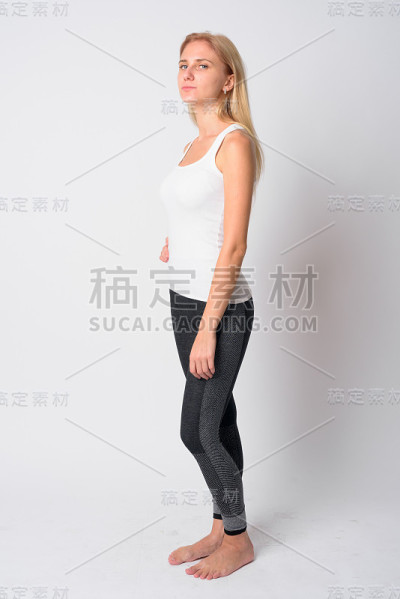 年轻的金发女人准备去健身房的全身照侧面视图