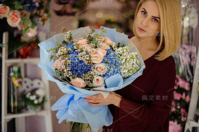可爱的女性，手里拿着蓝色的花束