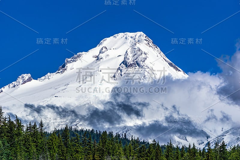 初夏时节，美国俄勒冈州，蓝蓝的天空衬托着青蛙湖上的胡德山，云朵覆盖着积雪。