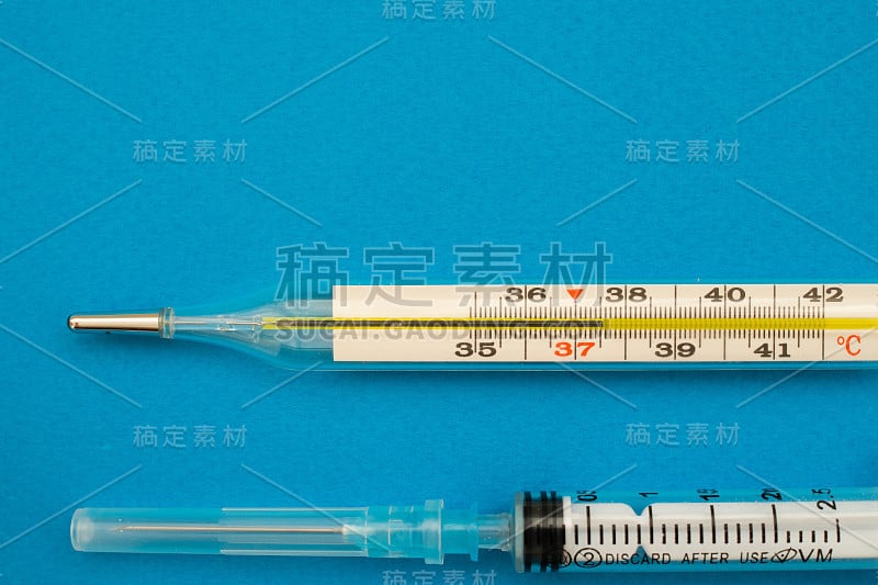 蓝色背景下的温度计和注射器。热量。拷贝空间，c37,5