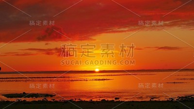 火红的落日在一个热带岛屿的地平线上慢慢消失。