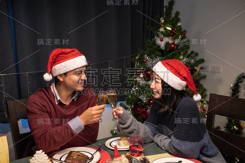 幸福的夫妇可爱的男人和女人微笑着一起庆祝圣诞夜在餐厅