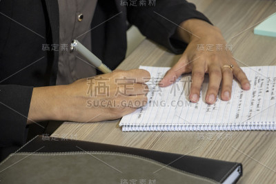 一个年轻的印度女人在写手写便条