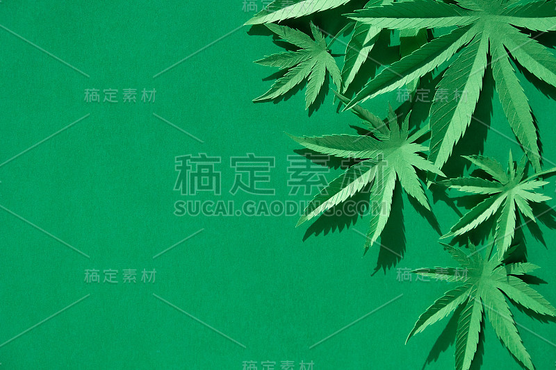 在绿色背景上用纸制成的大麻叶子