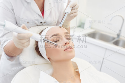 美容师在一个女孩客户脸上做微电流治疗