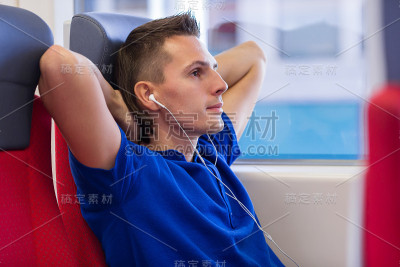 一个快乐的年轻人乘火车旅行，听着音乐