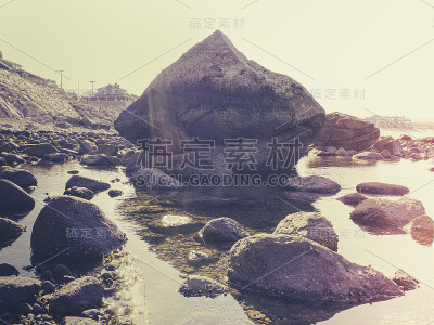 退潮时普利茅斯白马海滩上的巨石和岩石的复古风格形象