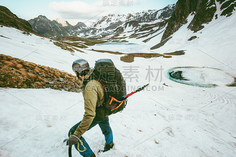 登山人带着大背包和冰斧登山旅行生活方式生存概念冒险户外活动假期极限运动装备野外自然雪山