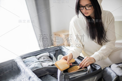 专注于女性整理旅行箱清单。衣服，化妆包，设备箱