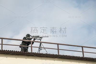 警察狙击手在屋顶上用光学瞄准器瞄准
