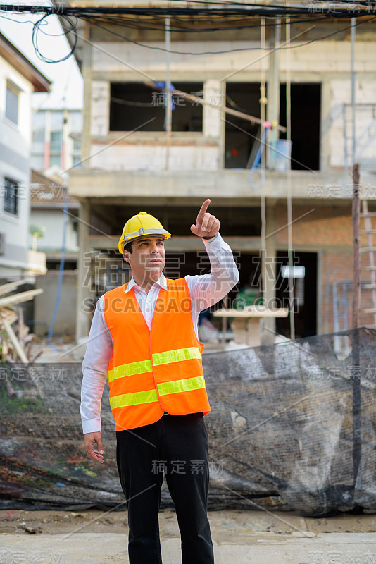 在建筑工地上英俊的波斯男子建筑工人的肖像