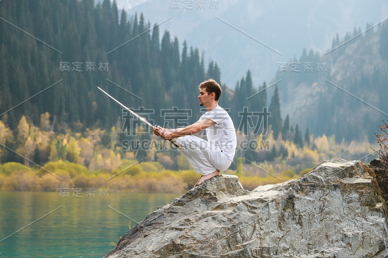 一个聪明人坐在石头上，手里拿着一把剑。山湖背景