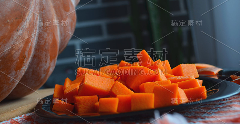 新鲜的生南瓜，切成小方块。Gray-orange背景。素食菜。