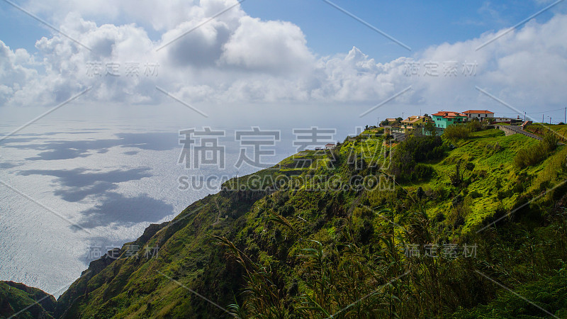 马德拉-在蓬塔多帕戈附近的海岸线上的绿色草地上五颜六色的房子