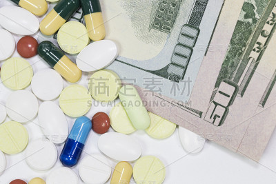 药品和美元摆在桌子上，药品的成本概念