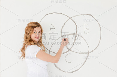 金发老师一边看着摄像机一边画方案