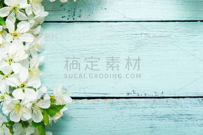 蓝色木桌上放着樱花