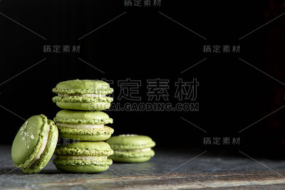 法式甜点马卡龙配开心果和草莓。暗的背景