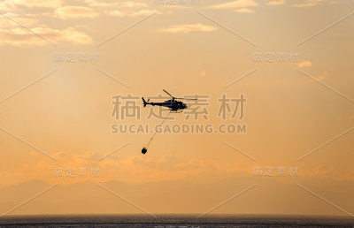 直升机从海里收集水来灭火