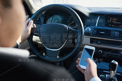一个男人一边开车一边打电话