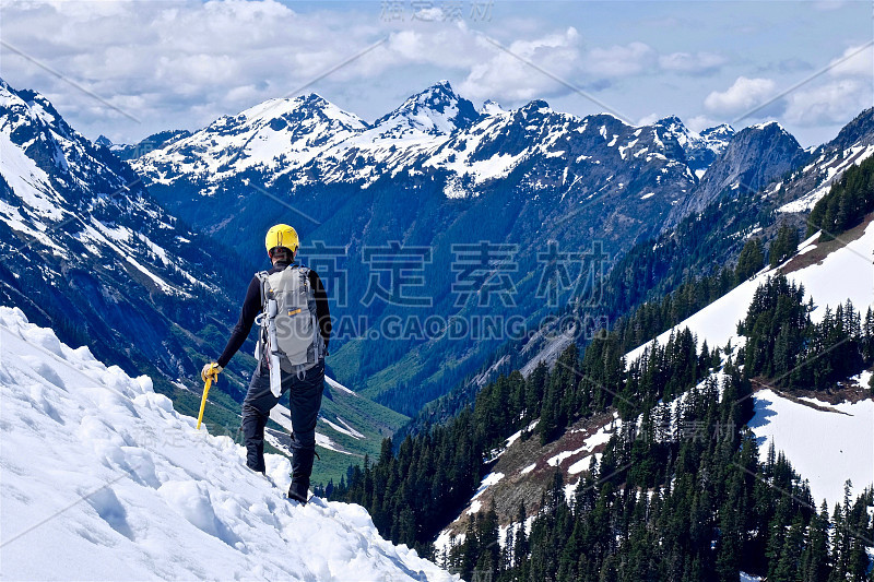 一个登山运动员站在山顶欣赏风景。