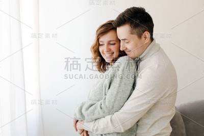可爱的夫妇在他们的家里拥抱和微笑