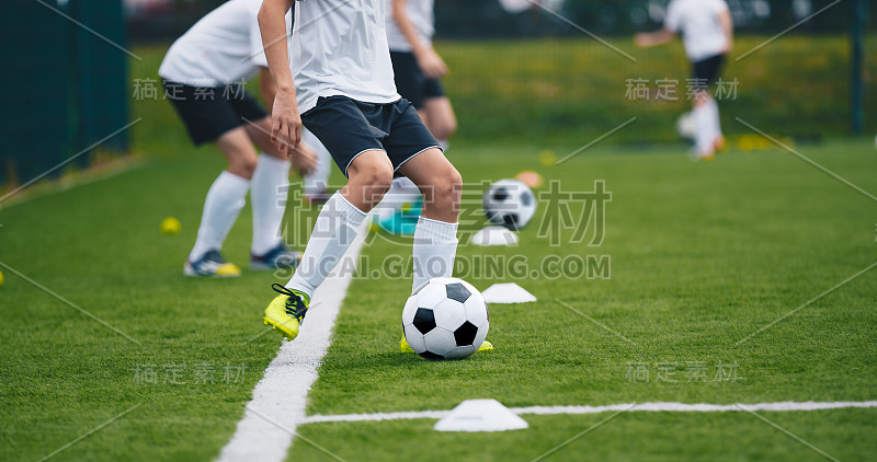 足球运动员在训练中。男孩踢足球的练习环节。孩子们在训练足球场踢足球。初级足球训练青少年