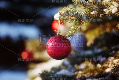 白雪覆盖的冬天森林里，圣诞树上的红色玩具球