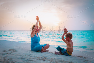 母子在海滩上做瑜伽的剪影
