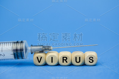 木方和注射器上的病毒字蓝色背景医学概念。