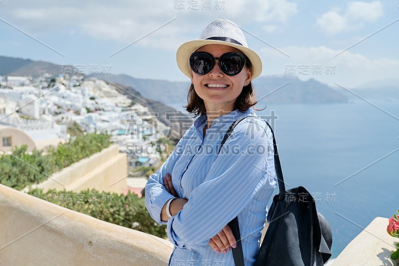 快乐成熟的女人在著名的圣托里尼岛旅游