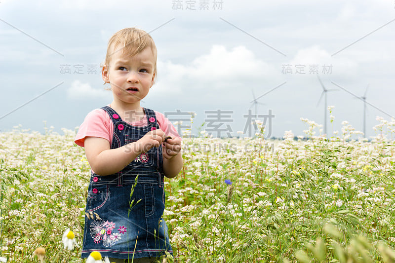 小可爱的高加索女孩期待在风力发电机涡轮机的背景概念