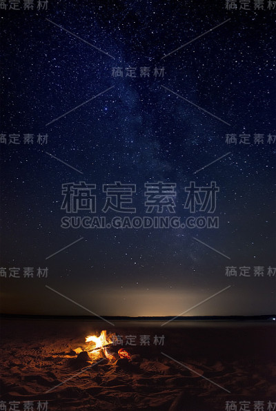 在繁星点点的天空下，一堆篝火在湖岸缓缓燃烧。银河系照亮了宇宙，用它的秘密召唤着我们。星光灿烂的夜空