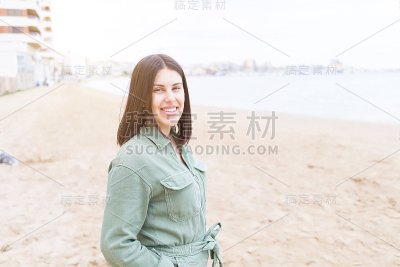 年轻漂亮的女人在海滩上笑得很开心