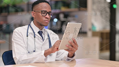 严肃的非洲专业男医生在办公室使用平板电脑