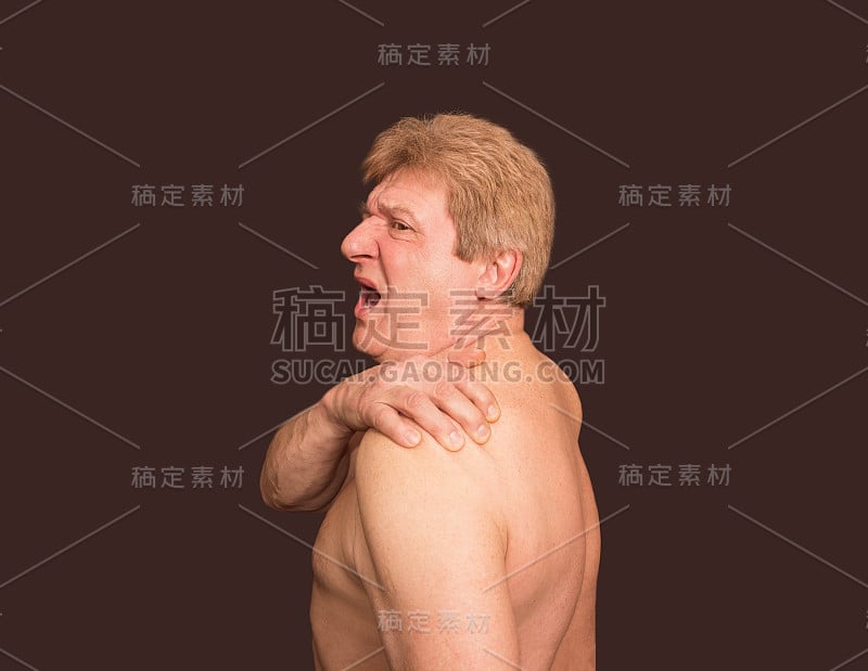 特写的年长赤膊男子与肩膀疼痛在黑色的背景