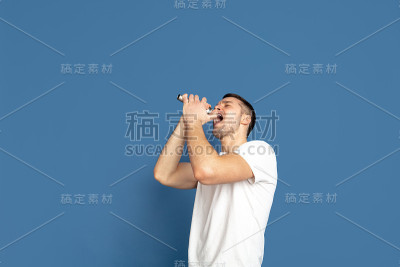 蓝色画室背景上的白人青年肖像