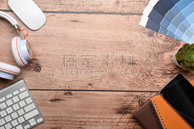 图形设计师的工作空间与键盘，耳机，色卡和笔记本木制的背景。